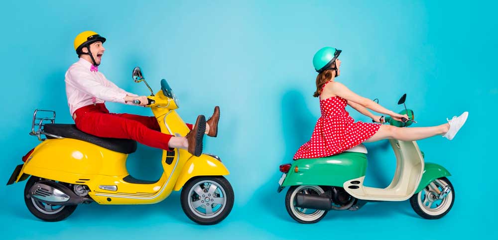 Två personer på mopeder i en färgglad omgivning som kör vilt.